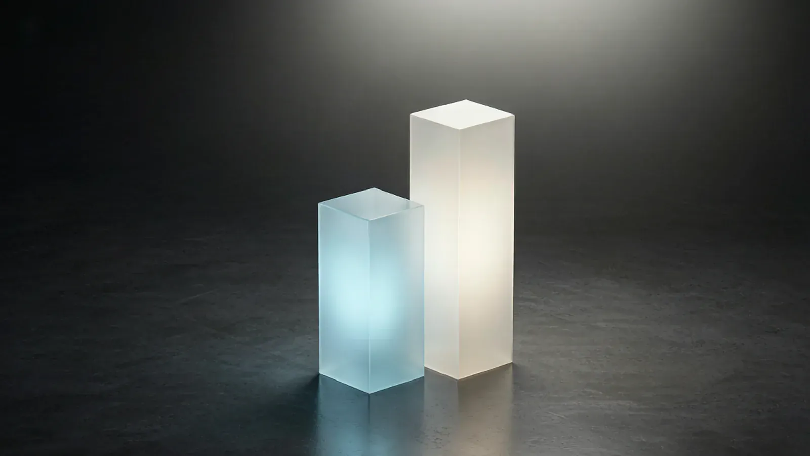 Two glowing translucent bars rising side by side, one taller than the other, above a dark floor